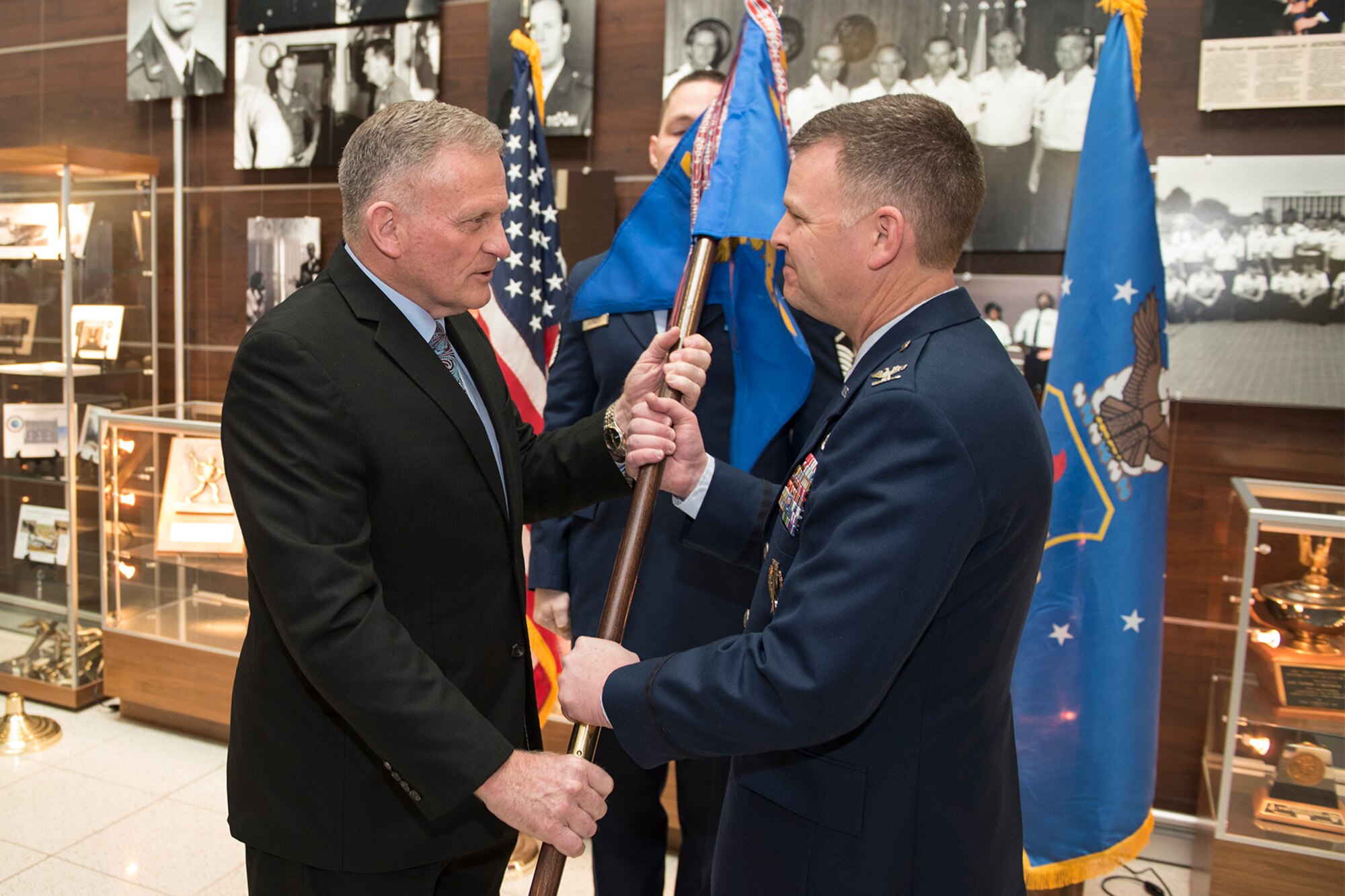 PETERSON AIR FORCE BASE, Colo. –Dr. Todd I. Stewart, Air Force Institute of Technology director and chancellor, passes the National Security Space Institute’s guidon to Col. Richard B. Van Hook, NSSI commandant, at the NSSI re-designation ceremony April 1, 2016. The passing of this flag represents transferring control of the NSSI from the Eaker Center to AFIT. (U.S. Air Force photo by Philip Carter)