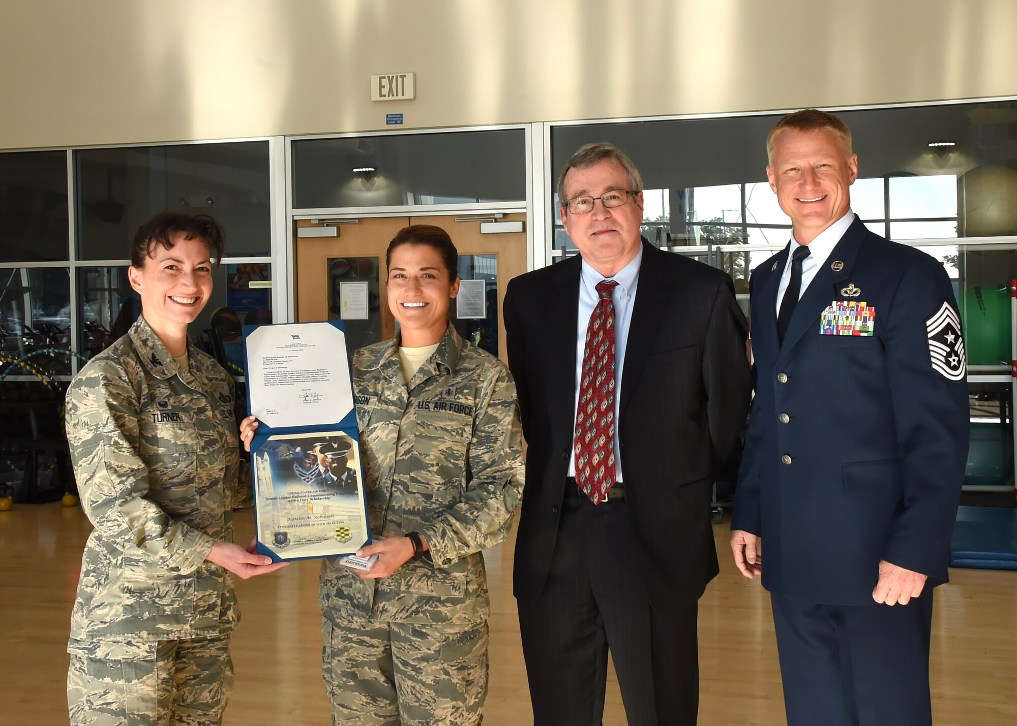 Staff Sgt. Katelin Robinson, 61st Medical Squadron noncommissioned officer in charge of Dental Logistics at the Los Angeles Air Force Base medical clinic in El Segundo, Calif.,  holds her certificate and letter of selection for Officer Training School through the Senior Leader Enlisted Commissioning Program from Gen. John Hyten, commander of Air Force Space Command with Col. Donna Turner, 61st Air Base Group commander, Thomas Fitzgerald, Space and Missile Systems Center acting executive director and Chief Master Sgt. Craig Hall, SMC command chief. (U.S. Air Force photo/Sarah Corrice)