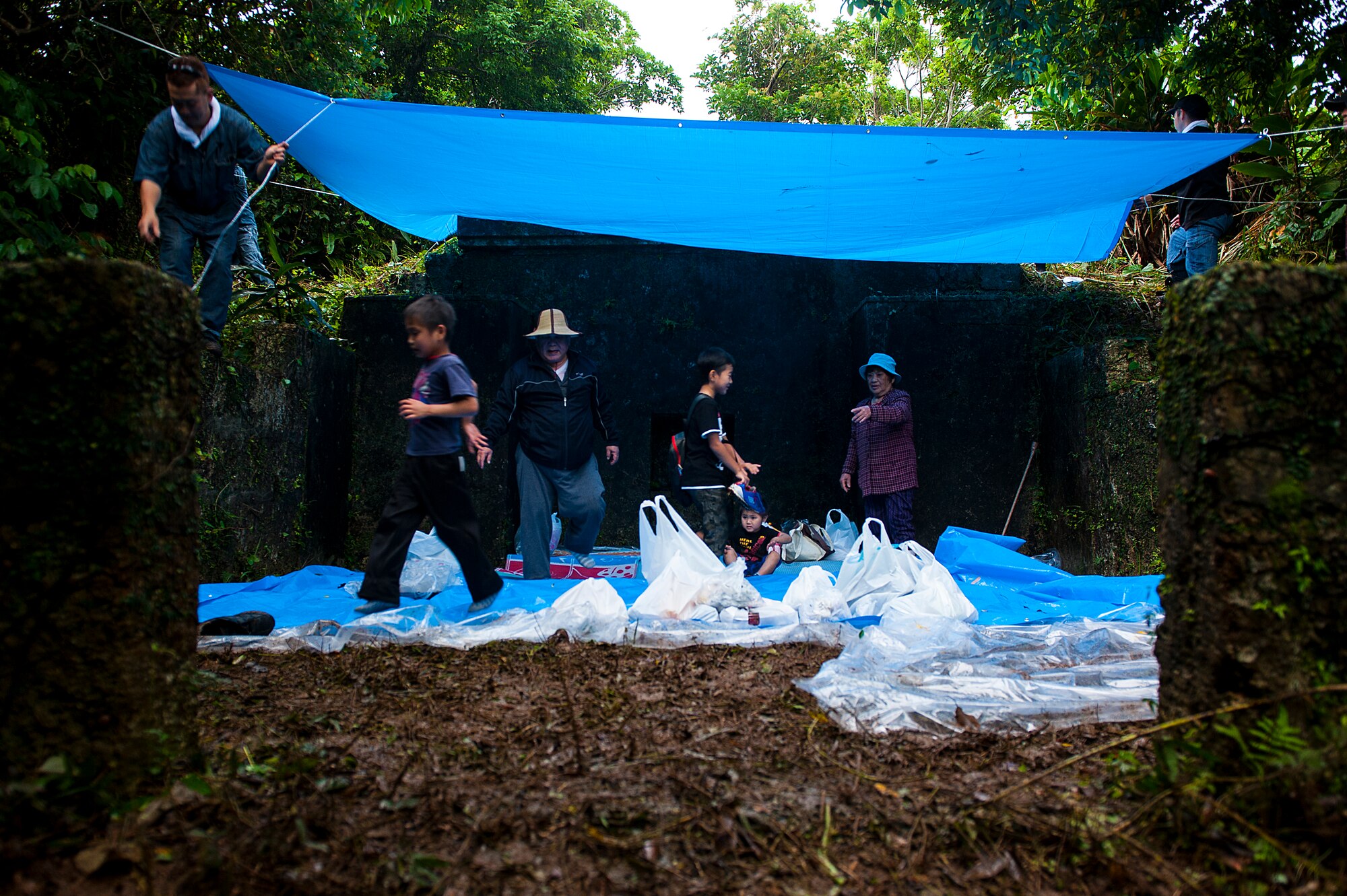 An Okinawan family prepares to pray and offer food to their ancestors for the annual “Shimi” celebration April 10, 2016, at Kadena Air Base, Japan. Okinawan families come onto Kadena’s munitions storage area, where tombs have been since before World War II, to pray and offer food as thanks to their ancestors. (U.S. Air Force photo by Airman 1st Class Corey M. Pettis)