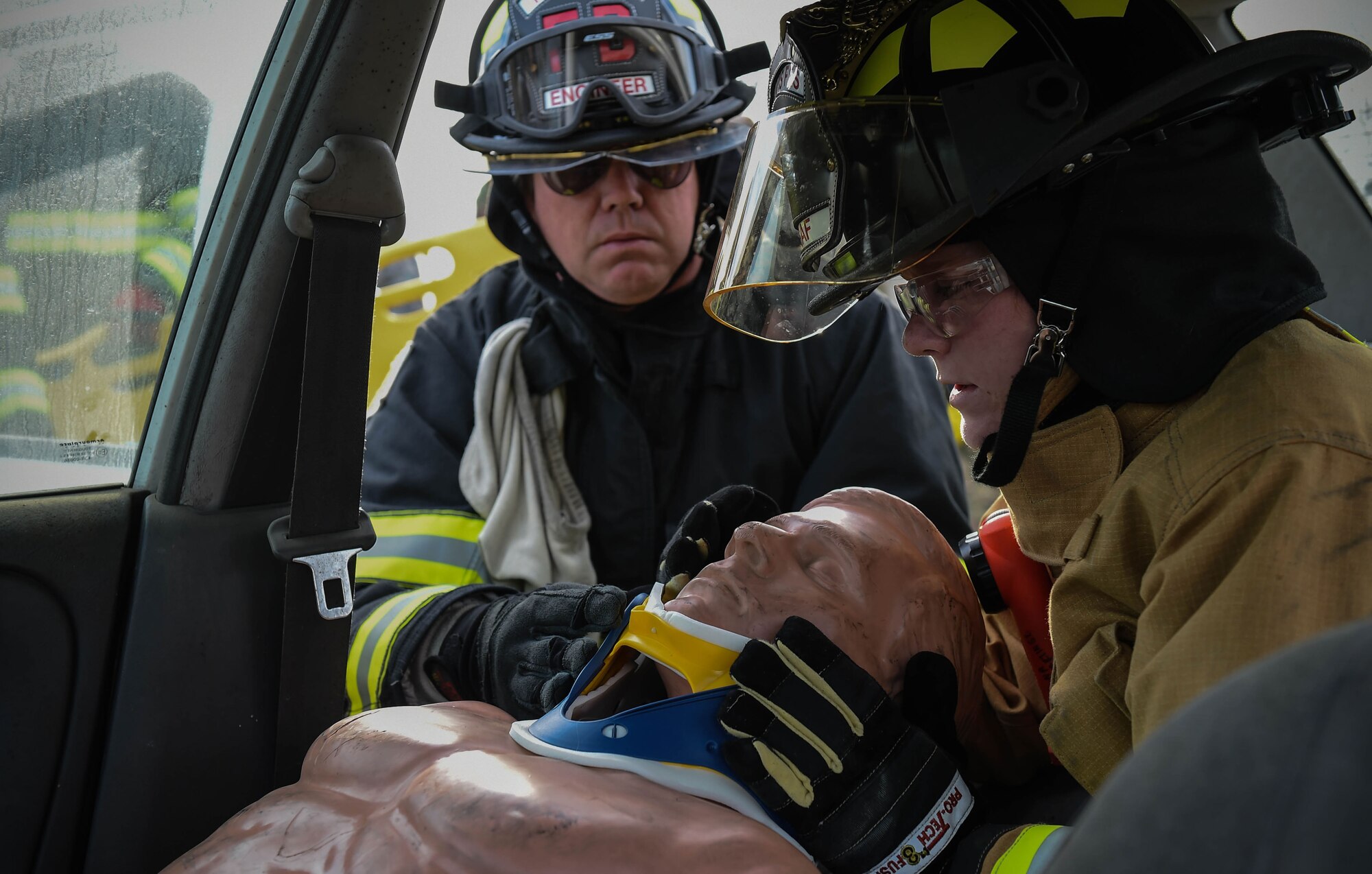 Mr. Paul Dahlen, left, and Airman 1st Class Angelica Redmond, both 60th Civil Engineering Squadron firefighters, apply a neck brace to a rescue dummy during vehicle extrication training April 7, 2016,  at Travis Air Force Base, California. The Team Travis fire department worked with the 571st Mobility Support Advisory Squadron on vehicle extrication for future deployments to South and Central America. (U.S. Air Force photo by Staff  Sgt. Robert  Hicks/Released)