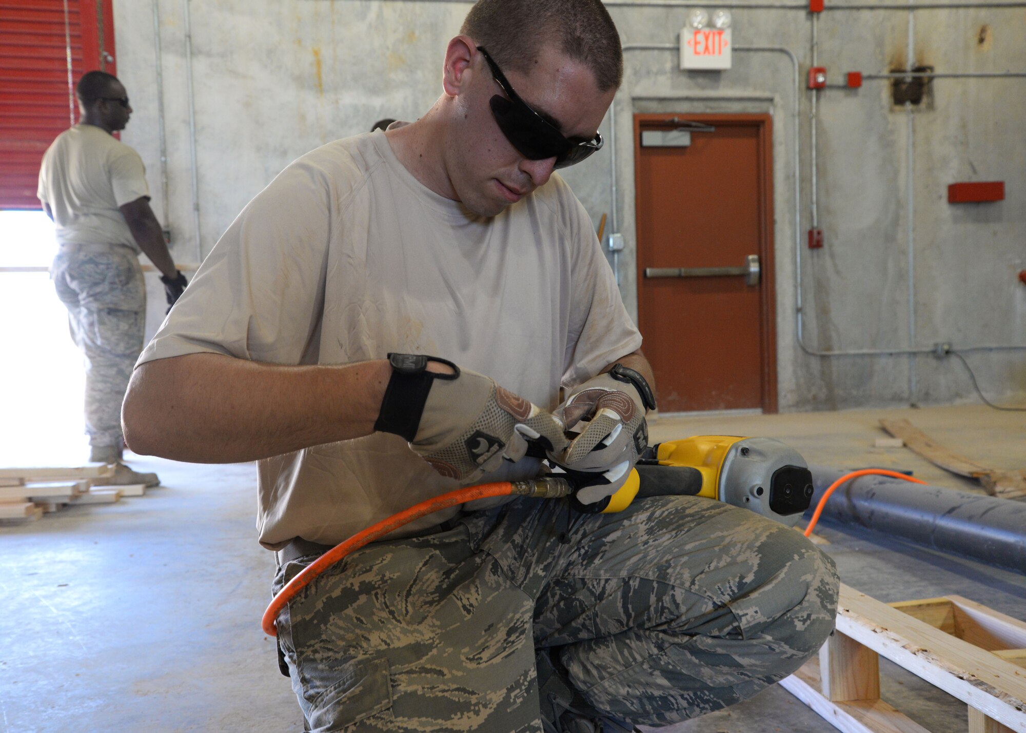 Staff  Sgt. Andrew Bracken, a firefighter from the 175th Wing, Maryland National Guard, reloads a nail gun to prepare material that will help shape the concrete floor of  a warehouse April 12, 2016 at Andersen Air Force Base, Guam. The 175th CES is the first of seven National Guard groups that will be working toward the completion of this project. (U. S. Air National Guard Photo by Airman 1st Class Enjoli Saunders/RELEASED)