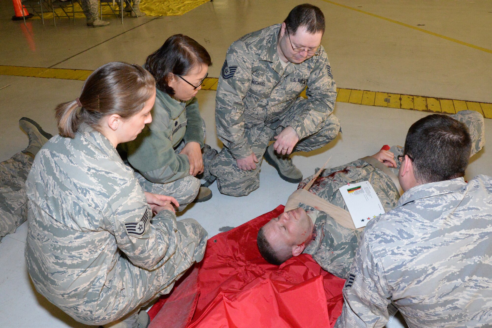 U.S. Air Force Airmen with the Indiana Air National Guard, 181st Intelligence Wing tend to a fellow Airman’s injury during an exercise at Hulman Field Air National Guard base, Ind., April 9, 2016. The exercise simulated an F-1 tornado passing through the base causing destruction to buildings and how the wing would respond. (U.S. Air National Guard photo by Senior Airman Lonnie Wiram)