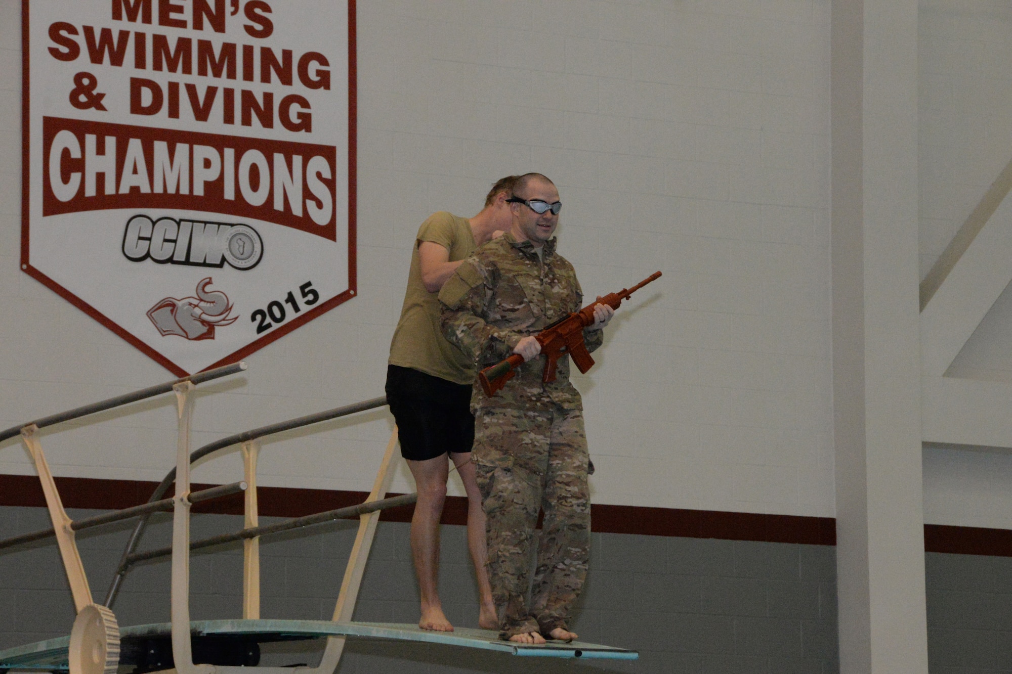 U.S. Air Force Airmen assigned to the Indiana Air National Guard, 181st Intelligence Wing, 113th Air Support Operation Squadron prepares to be pushed off of a high diving board while blind-folded to simulate an unexpected water entry during a night combat patrol at the Sports and Recreation Center on the campus of Rose-Hulman Institute of Technology in Terre Haute Feb. 6, 2016. The Airman trained on four different areas that tested different swimming methods in a combat situation. (U.S. Air National Guard photo by Senior Airman Lonnie Wiram)