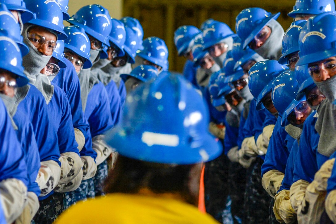 Sailors listen for instruction as they practice handling hoses during a drill in the hangar bay of the USS Gerald R. Ford in Newport News, Va., March 31, 2016. The shipwide training drill focused on damage control and emergency responses. Navy photo by Petty Officer 2nd Class Ryan Litzenberger