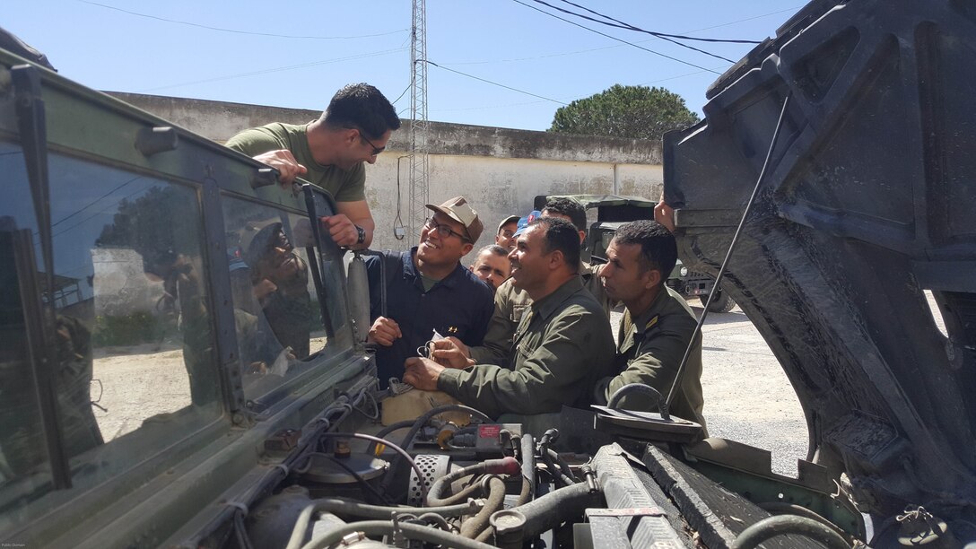 Sgt. Doug Lancie, a motor transportation mechanic, talks about engine parts with Tunisian Groupement des Forces Speciales soldiers during training in Bizerte, Tunisia, Mar. 21- Apr. 8, 2016. The Marine vehicle maintenance and assistance team trained with the GFS to increase counter terrorism capabilities through motor transportation operations and maintenance training.