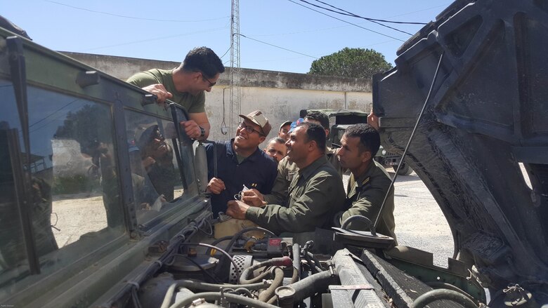 Sgt. Doug Lancie, a motor transportation mechanic, talks about engine parts with Tunisian Groupement des Forces Speciales soldiers during training in Bizerte, Tunisia, Mar. 21- Apr. 8, 2016. The Marine vehicle maintenance and assistance team trained with the GFS to increase counter terrorism capabilities through motor transportation operations and maintenance training.