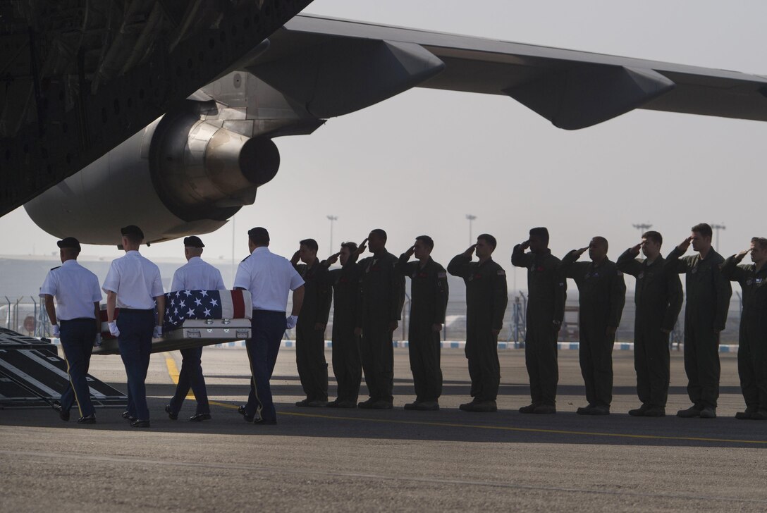 The crew of an Air Force C-17 Globemaster III salutes, April 12, 2016, in New Delhi, as soldiers from the Defense POW/MIA Accounting Agency escort a transfer case containing the possible remains of American service members lost over India during World War II. Defense Secretary of Ash Carter attended the ceremony as part of his trip to India. DoD photo by Air Force Senior Master Sgt. Adrian Cadiz