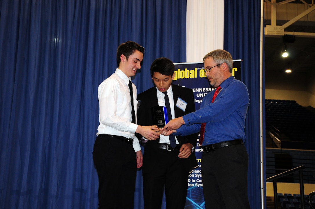 Ben Rohrbach, chief, Nashville District Hydraulics and Hydrology presents Peyton Ball and Michael Chan with a glass trophy and certificate for their Science, Technology, Engineering and Math project at a science expo sponsored by the Middle Tennessee STEM Innovation Hub at the Tennessee State University  in Nashville, Tenn., on April 7, 2016. 