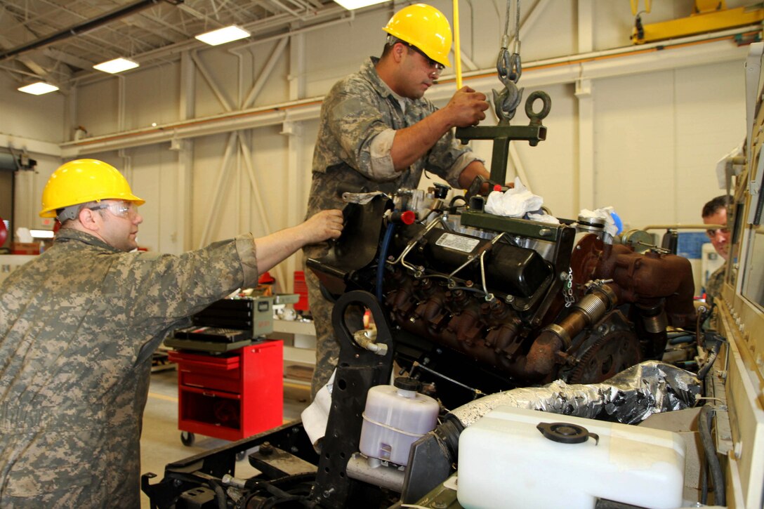Sgt. Dana Gault (l), 978th Quartermaster Co., and Spc. Ilmer Canales, 126th Brigade Support Battalion, remove a Humvee’s engine during the 80th Training Command's Wheeled Vehicle Mechanic Course at the Regional Training Site-Maintenance Fort Devens, 31 March 2016.   The three-week course teaches students the basics of how to perform maintenance and repairs on four-wheeled military vehicles, primarily focusing on Humvees and Mine-Resistant Ambush Protected vehicles.