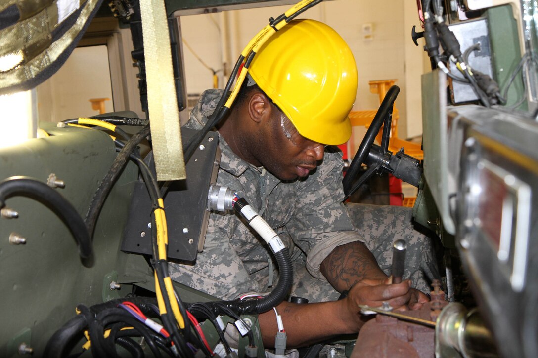 Spc. Abraham Keith of the 318th Chemical Co. out of Birmingham, Ala. works on loosening the engine from inside a humvee as he and his fellow students take apart the engine block and remove the humvee's engine as part of a training task during the first phase of the 80th Training Command's Wheeled Vehicle Mechanic Course at the Devens Regional Training Site Maintenance facility, 31 March 2016.   The three-week course teaches students the basics of how to perform maintenance and repairs on four-wheeled military vehicles, primarily focusing on humvees and Mine-Resistant Ambush Protected vehicles.