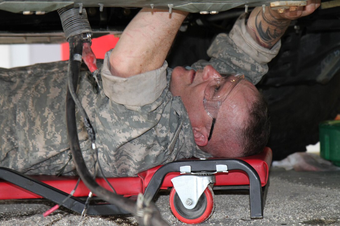 Sgt. Douglas Aho of the 110th Maintenance Co., Ft. Devens, Mass., re-connects the fuel supply line underneath a Humvee as he and his fellow students reassemble the vehicle. The students took the Humee engine apart during their final training task while attending the first phase of the 80th Training Command's Wheeled Vehicle Mechanic Course at the Regional Training Site-Maintenance Fort Devens, 31 March 2016. The three-week course teaches students the basics of how to perform maintenance and repairs on four-wheeled military vehicles, primarily Humvees and Mine-Resistant Ambush Protected vehicles.