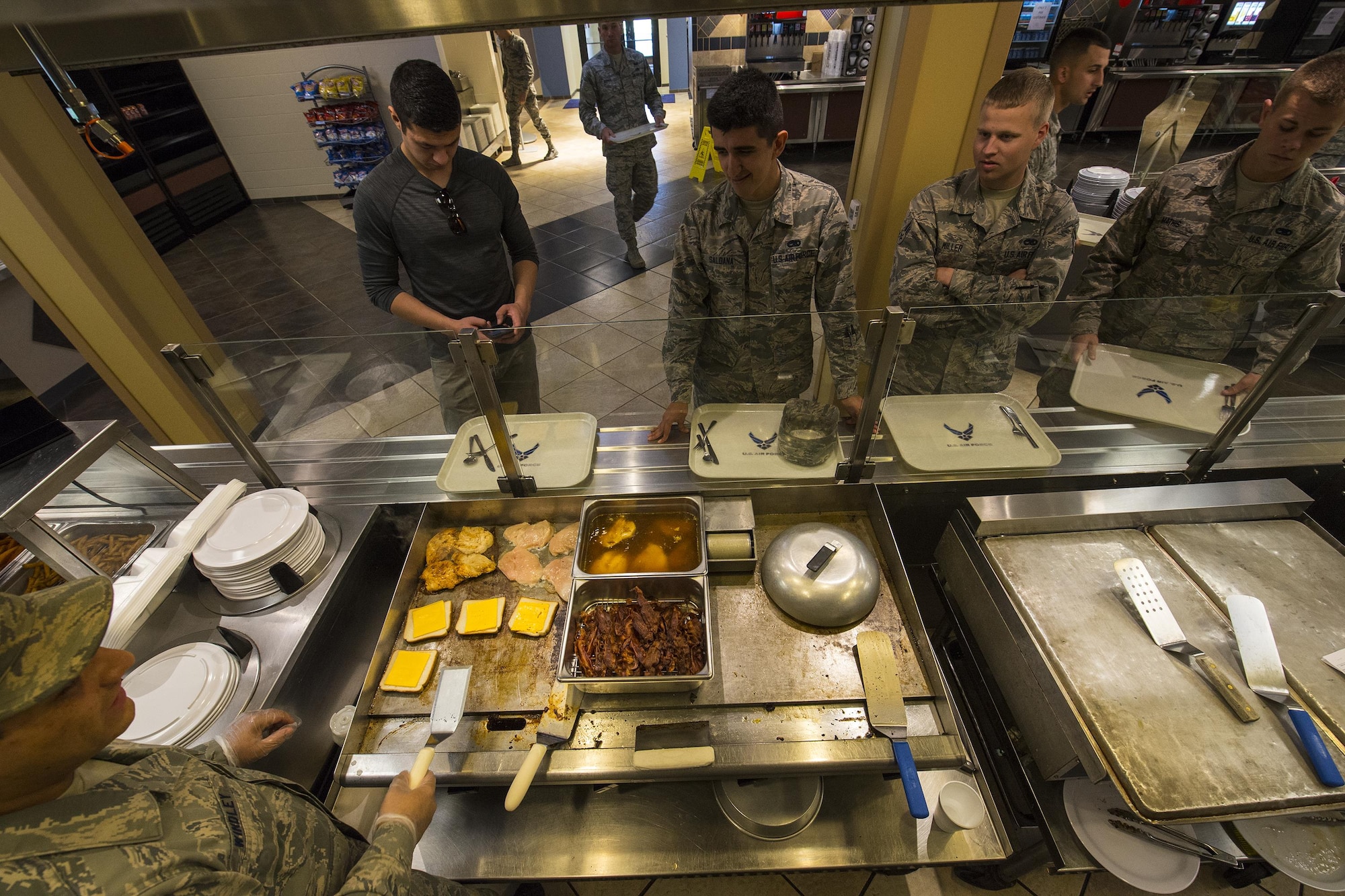 U.S. Air Force Airmen wait in line for their lunch, April 7, 2016, at Moody Air Force Base, Ga. The Georgia Pines Dining Facility offers weekly cultural foods including Mexican, British and Italian style meals. (U.S. Air Force photo by Airman Daniel Snider/Released)