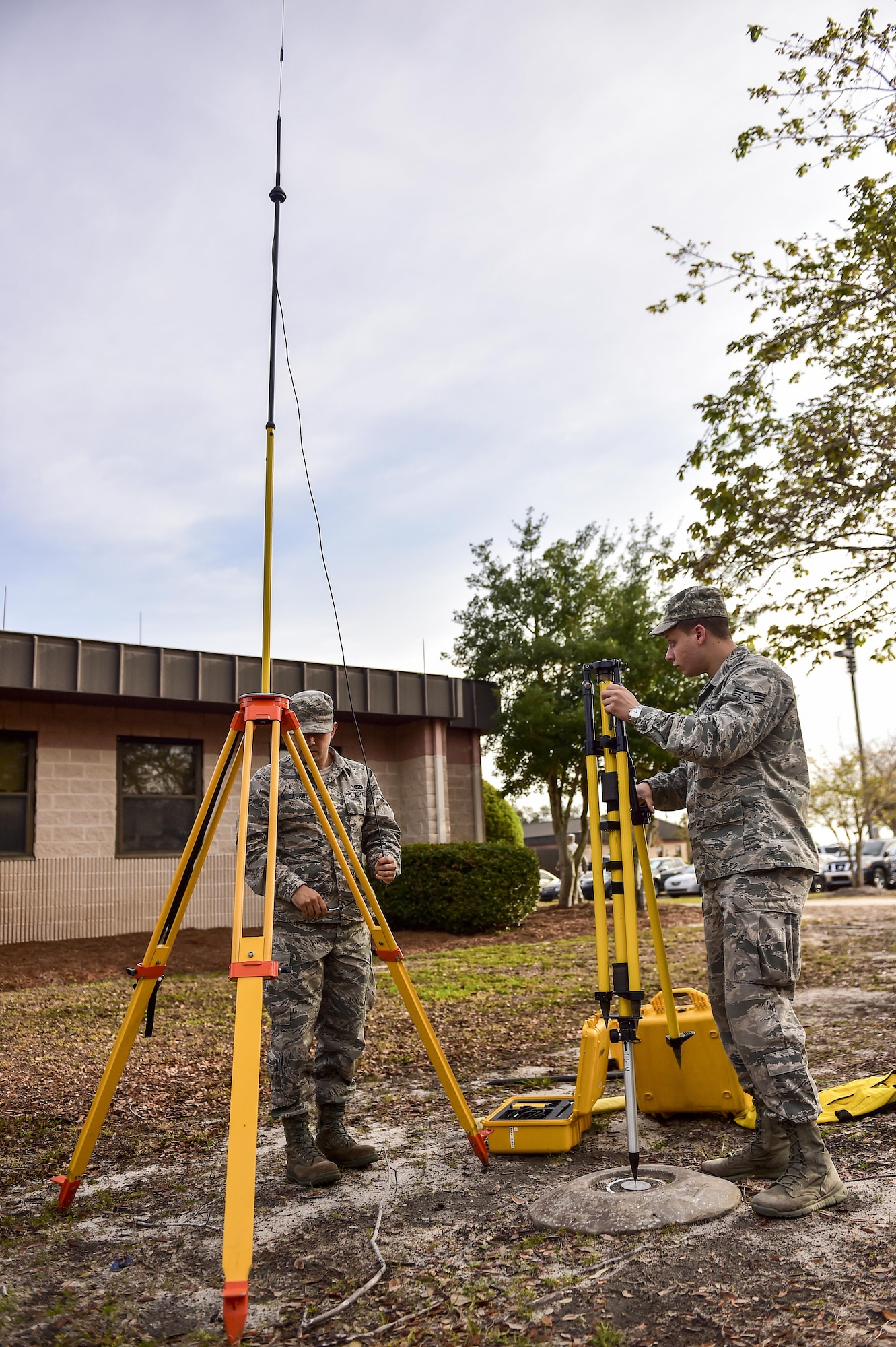 Airman 1st Class Mohamed Al Dawali and Senior Airman Adam Gleason, engineering journeymen with the 1st Special Operations Civil Engineer Squadron, set up a base station for a GPS rover at Hurlburt Field, Fla., March 30, 2016. The GPS rover is used to pinpoint locations on base for surveying potential construction sites or future projects. It can also be used for setting points for airfield boundaries, locations and bare base planning. (U.S. Air Force photo by Senior Airman Jeff Parkinson)