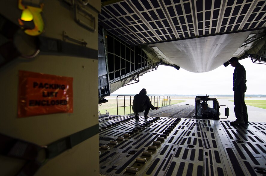 Master Sgt. Tim Morgan (left), a loadmaster with the 709th Airlift Squadron, guides a Navy transporter loader prior to off-loading cargo from the C-5M Super Galaxy March 30, 2016, at Naval Air Station Pensacola. Reservists from Dover Air Force Base, Del., in the 512th Airlift Wing, conducted an off-station training exercise March 29 through April 3 to ensure they are current in all their deployment requirements. (U.S. Air Force photo/Capt. Bernie Kale)