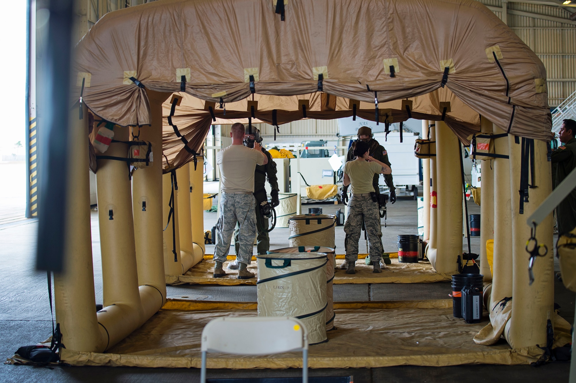 Reservists from Dover Air Force Base, Del., in the 512th Airlift Wing, get inspected on their chemical protective suits by 436th Airlift Wing aircrew flight equipment specialists, March 31, 2016, at Naval Air Station Pensacola, Fla. Air crew members from the 709th Airlift Squadron conducted an off-station training exercise, March 29 through April 3 trained in mission readiness and combat related areas and worked together to build wingmanship and teamwork. (U.S. Air Force photo/Capt. Bernie Kale)