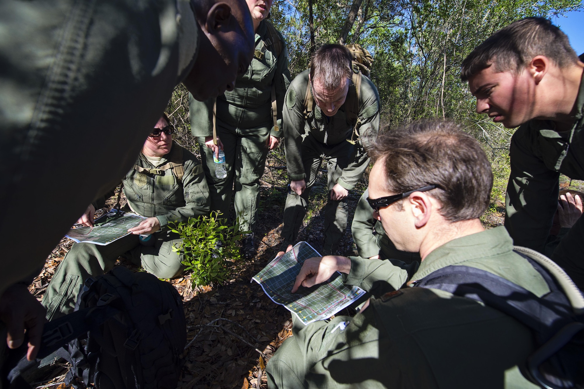 A group of 512th Airlift Wing reservists discuss their next movement while conducting land navigation, April 2, 2016, at Naval Air Station Pensacola, Fla., as part of an aircrew deployment recurrency training event. Instructors from active-duty and Air Force Reserve and the Navy helped provide a seamless, multi-service cadre for the trainees. (U.S. Air Force photo/Capt. Bernie Kale)