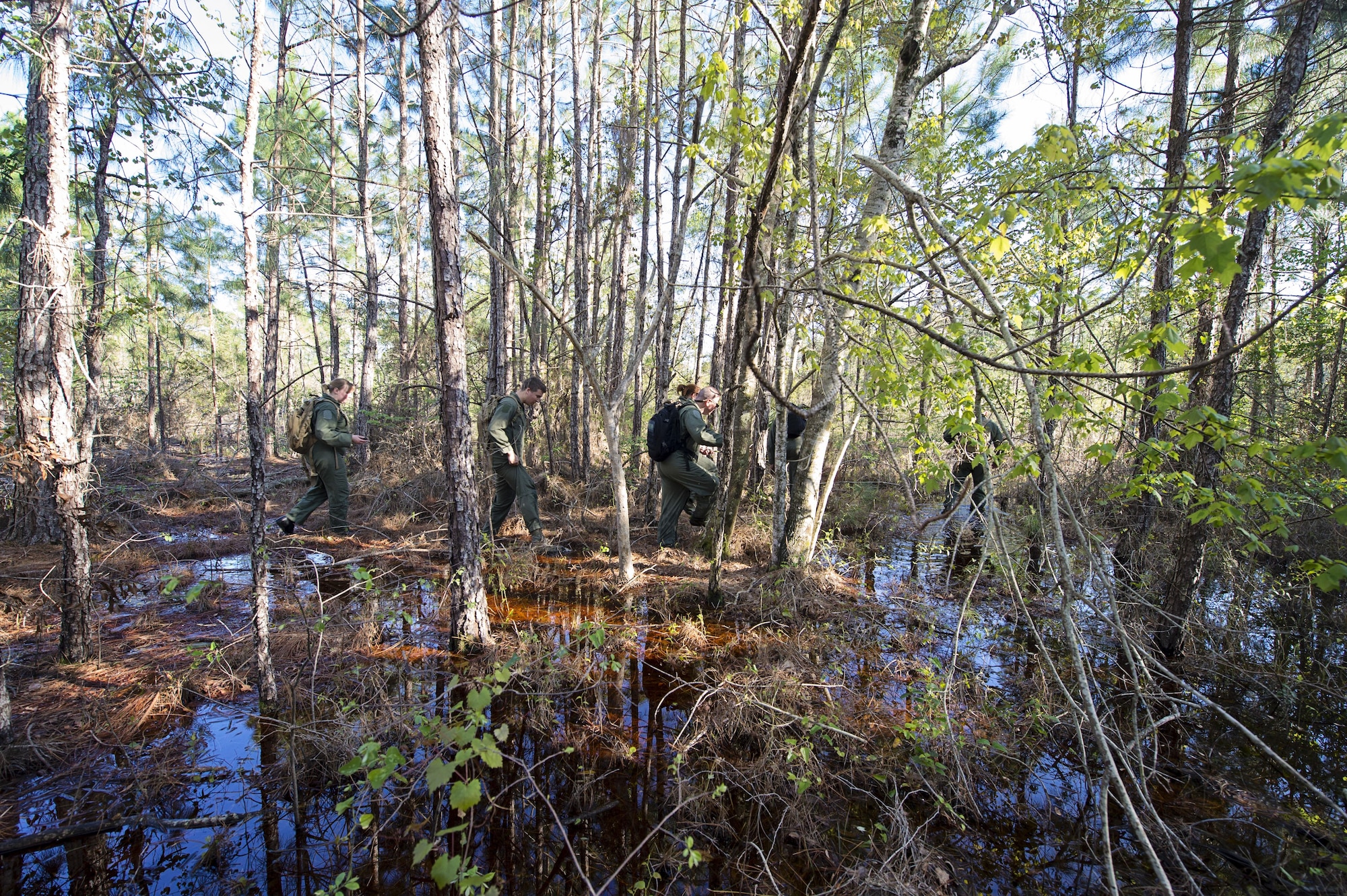 A group of 709th Airlift Squadron reservists navigate their way through the marsh, April 2, 2016, at Naval Air Station Pensacola, Fla., during their evasion portion of training. Reservists from Dover Air Force Base, Del., in the 512th Airlift Wing, conducted an off-station training exercise at Naval Air Station Pensacola, Fla., March 29 to April 3 to ensure they are current in all their deployment requirements. (U.S. Air Force photo/Capt. Bernie Kale)