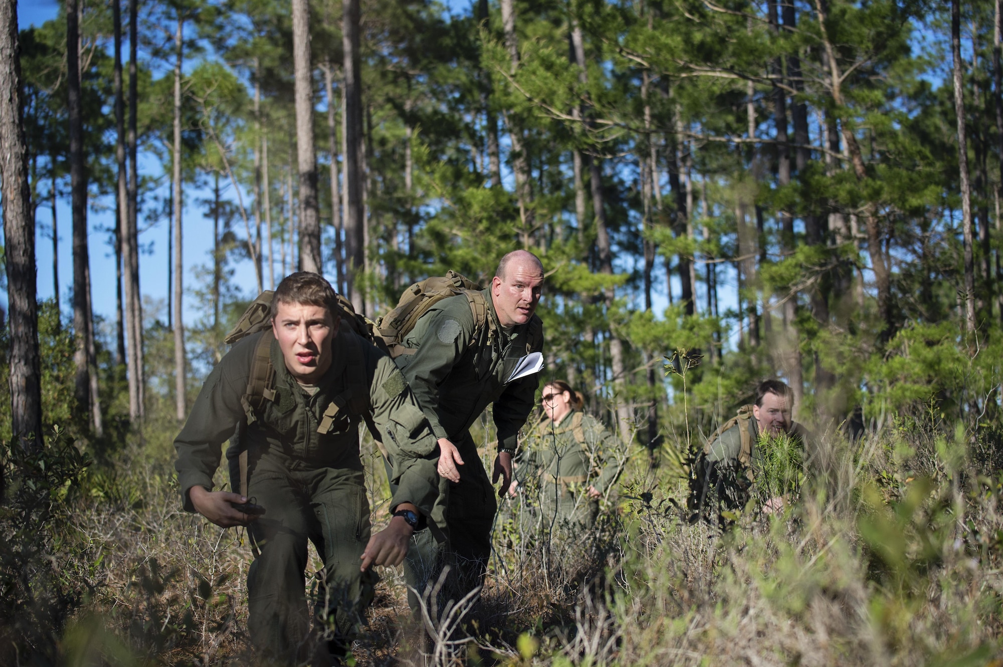 Senior Airman Jake Voshell (left), a loadmaster with the 709th Airlift Squadron, leads his team through the simulated evasion portion of combat training, April 2, 2016, at Naval Air Station Pensacola, Fla. Reservists from Dover Air Force Base, Del., in the 512th Airlift Wing, conducted an off-station training exercise, March 29 to April 3, to ensure they are current in all their deployment requirements. (U.S. Air Force photo/Capt. Bernie Kale)