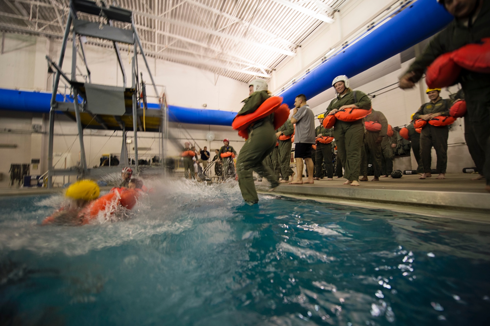 Reservists from Dover Air Force Base, Del., in the 709th Airlift Squadron, jump into a 12-foot deep pool at Naval Air Station Pensacola, April 1, as part of their water survival recurring requirement. The squadron conducted an off-station training exercise, March 29 through April 3 to ensure they are current in all their deployment requirements. (U.S. Air Force photo/Capt. Bernie Kale)