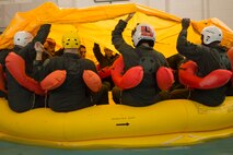 Reservists from Dover Air Force Base, Del., in the 709th Airlift Squadron, work together to mount the life raft canopy above them while learning how to protect themselves from the elements at Naval Air Station Pensacola, Fla., April 1, 2016. The squadron conducted an off-station training exercise March 29 through April 3 to ensure they are current in all their deployment requirements. (U.S. Air Force photo/Capt. Bernie Kale)