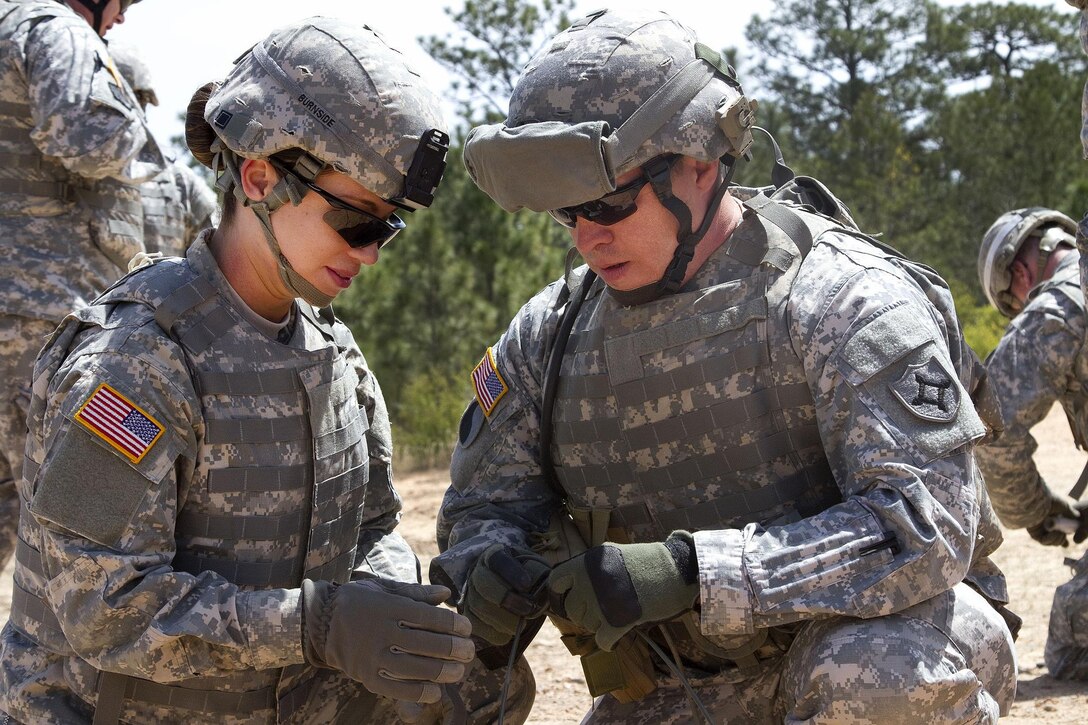 Army Spc. Maryi Burnside, left, and Sgt. Vic Harper prepare a piece of detonation cord with that will be attached to a block of composition C4 explosives at McCrady Training Center, in Eastover, S.C. April 10, 2016. Burnside and Harper are assigned to the Florida National Guard’s 779th Engineer Battalion. Air National Guard photo by Sgt. Brad Mincey
