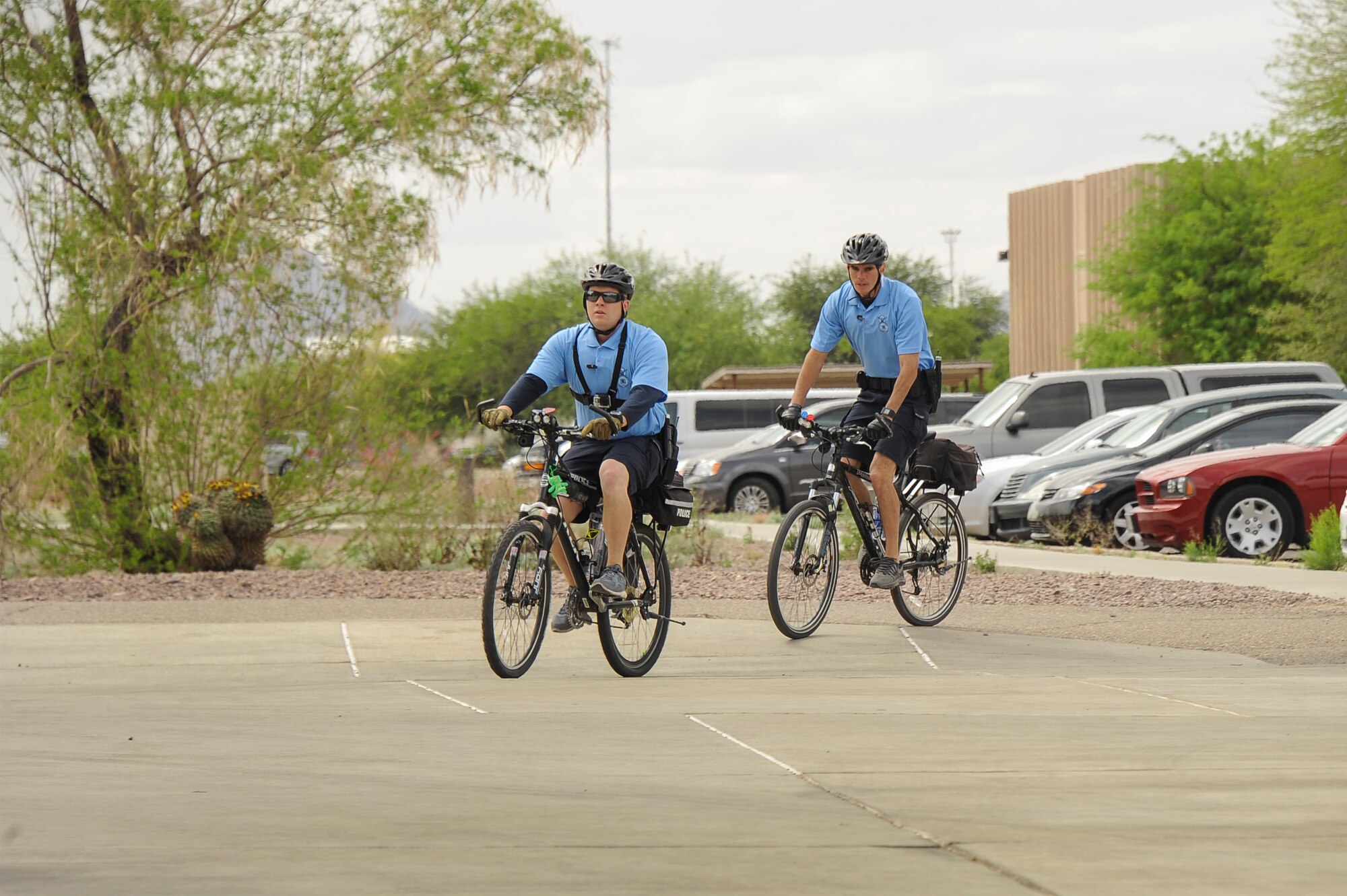 U.S. Air Force Staff Sgts. Johnny Nunnes and Damien Lyn, 355th Security Force Squadron base defense operations center controllers, patrol the entrance of the Exchange at Davis-Monthan Air Force Base, Ariz., March 30, 2016. Traveling on bicycle helps the defenders with faster response times by allowing them to travel through places that a patrol car cannot. (U.S. Air Force photo by Airman 1st Class Mya M. Crosby/Released)