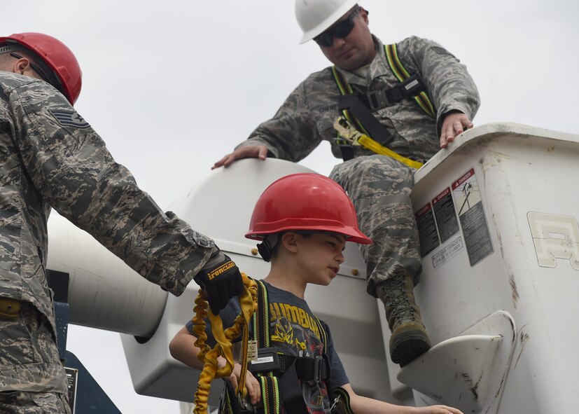 Staff Sgt. James Chenevert, a heavy equipment operator with the 823rd RED HORSE Squadron, takes his son, David, for a ride in a bucket truck at Hurlburt Field, Fla., April 6, 2016. The RED HORSE squadron held an open house at their compound to showcase their mission to family, friends and former RED HORSE members. (U.S. Air Force photo by Airman 1st Class Kai White)