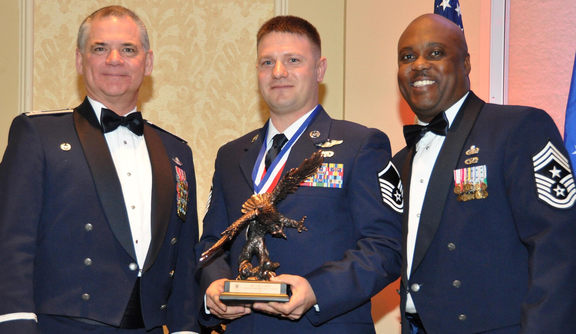 Master Sgt. Eric Cross , center, accepts the 302nd Airlift Wing’s 2015 Outstanding Noncommissioned Officer of the Year award from Col. Jack H. Pittman, Jr., left, 302nd AW commander, and Chief Master Sergeant Otis L. Jones, 302nd AW command chief master sergeant. Shaw received the award at the 302nd AW annual awards dinner March 5, 2016. (U.S. Air Force photo/2nd Lt. Stephen Collier) 