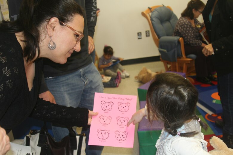 Scarlett, 3, identifies the different feelings on a feelings chart for her mother.