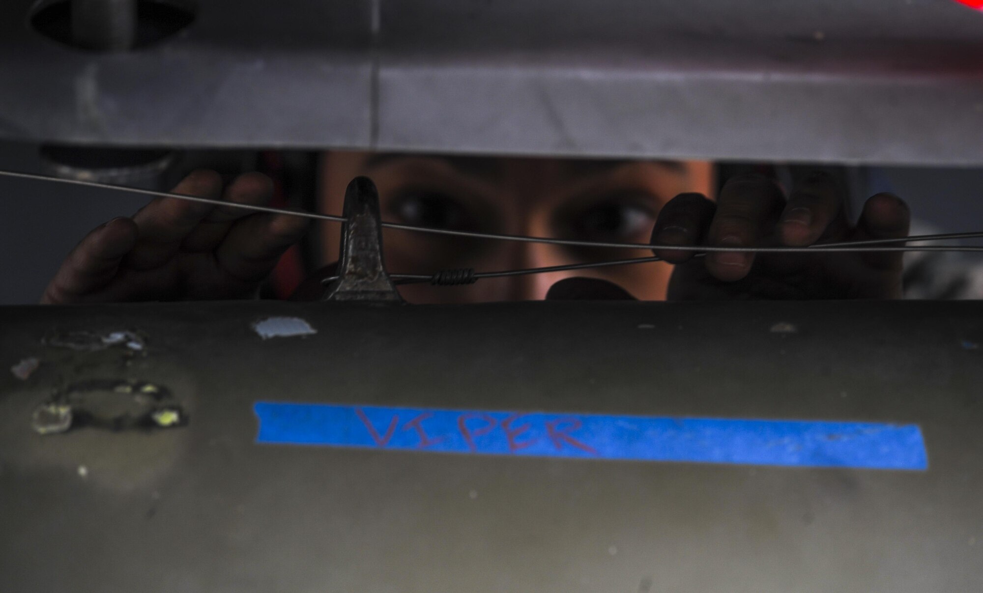 Member of a load crew checks the wires attached to an armament during the 57th Wings Load Crew of the Quarter Competition at Nellis Air Force Base, Nev., April 8, 2016. The quarterly competition highlights airmen for their loading skill and duty performance. (U.S. Air Force photo by Airman 1st Class Kevin Tanenbaum)