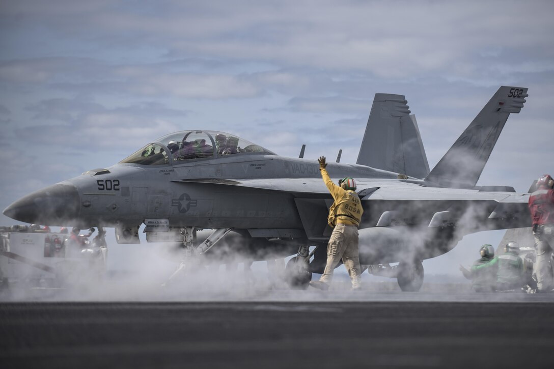 Navy Chief Warrant Officer 3 Hector Arroyo signals to an EA-18G Growler on the flight deck of the aircraft carrier USS Dwight D. Eisenhower in the Atlantic Ocean, April 11, 2016. The Growler is assigned to Electronic Attack Squadron 130. Navy photo by Petty Officer 3rd Class J. Alexander Delgado