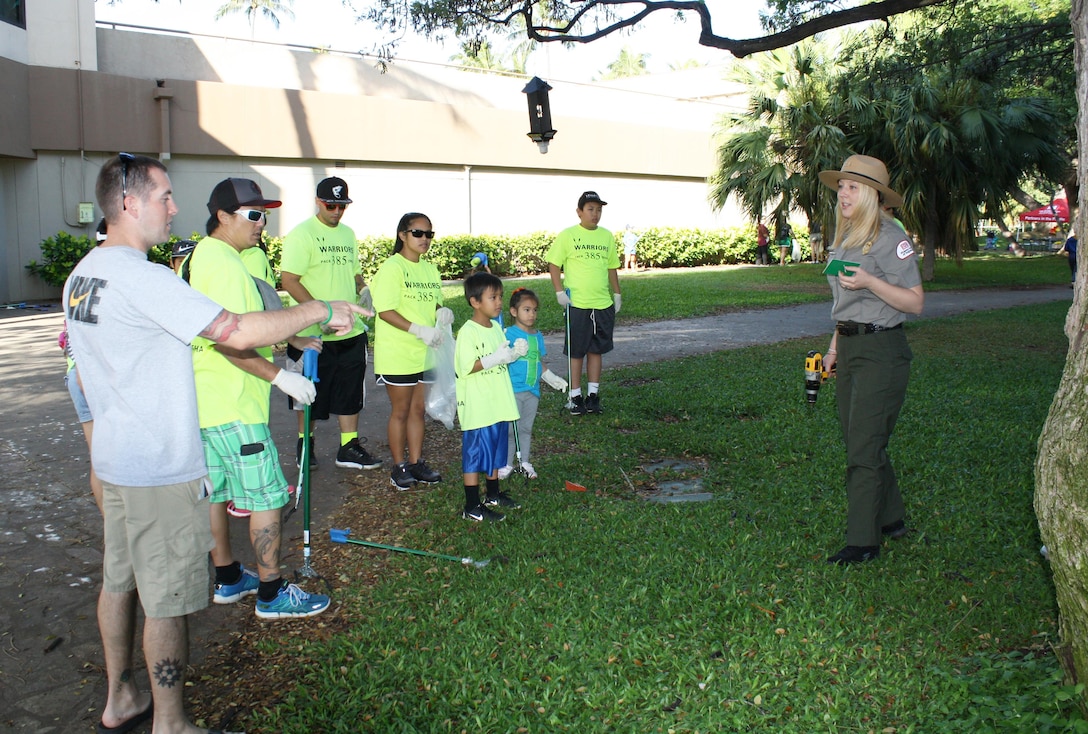 U.S. Army Corps of Engineers' Park Ranger Samantha Vazquez explains to Earth Day volunteers the process of placing name placards on tree trunks in Fort DeRussy Park area near the Corps'  Pacific Regional Visitor Center. More than 50 volunteers from the U.S. Army Corps of Engineers partnered with local JROTC students and others to clean up Waikiki Beach April 2 as part of Earth Month 2016.  