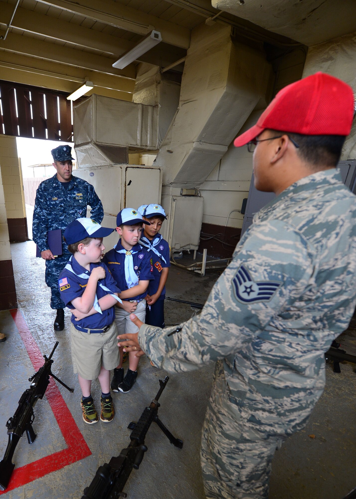 Staff Sgt. Dean Concepcion, from the 647th Security Forces Squadron, talks to Cub Scouts from Pack 388 during a tour of the 647th SFS on Joint Base Pearl Harbor-Hickam, April 5, 2016. During the tour, members of the 647th SFS provided weapon, fingerprint and vehicle demonstration to the Cub Scouts in Den Five of Pack 388. (U.S. Air Force photo by Tech. Sgt. Aaron Oelrich/Released)
