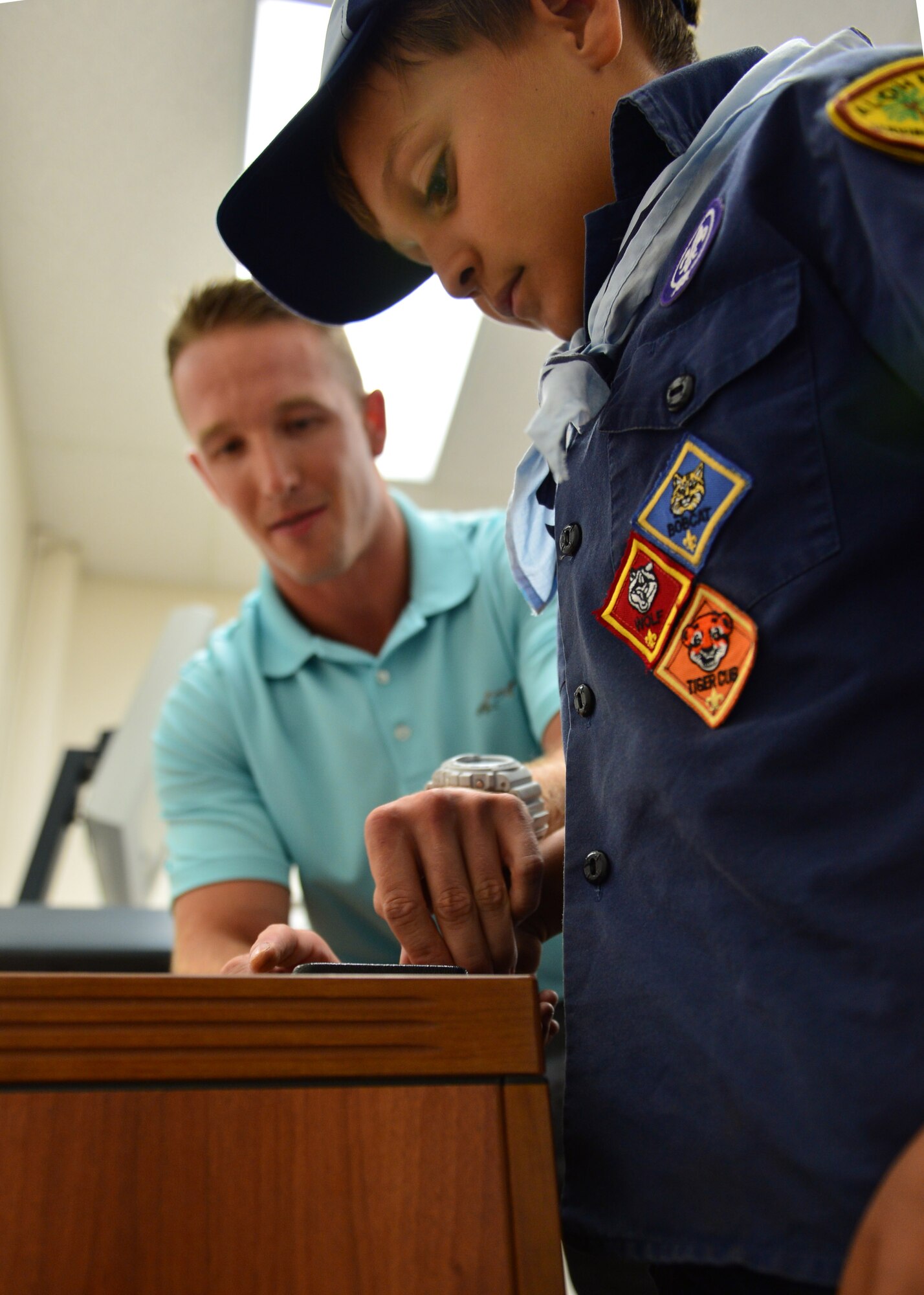 Investigator Dustin Doyea, 647th Security Forces Squadron, demonstrates to Cub Scout Chris Roberts, from Pack 388, how finger prints are documented during a tour of the 647th SFS, on Joint Base Pearl Harbor-Hickam, April 5, 2016. During the tour, members of the 647th SFS provided weapon, fingerprint and vehicle demonstration to the Cub Scouts in Den Five of Pack 388. (U.S. Air Force photo by Tech. Sgt. Aaron Oelrich/Released)

