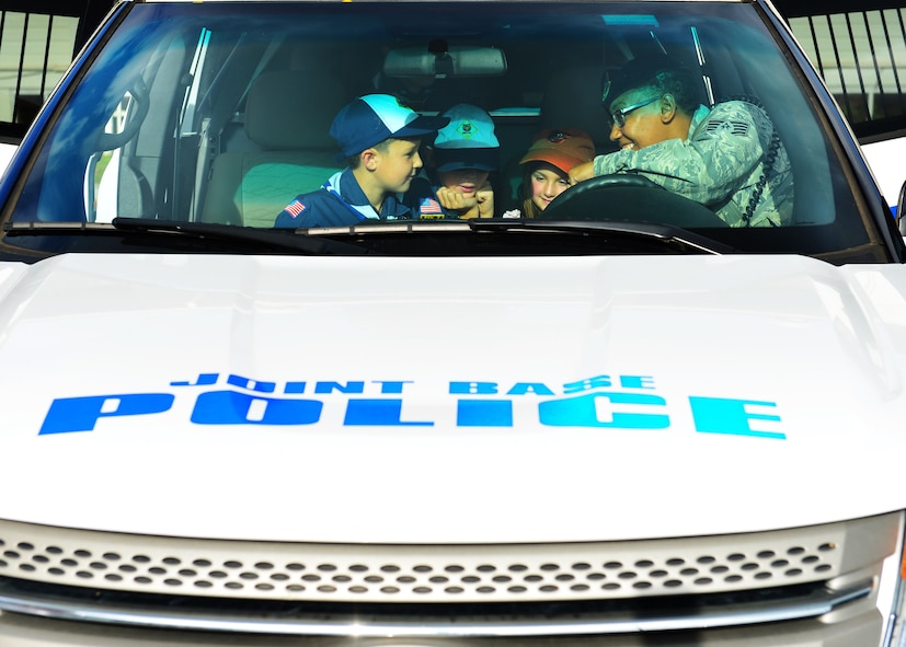 Staff Sgt. Yvonne Burnett, 647th Security Forces Squadron, gives members Cub Scout from Pack 388 a look at the different equipment installed on a 647th SFS patrol vehicle during a tour of the 647th SFS, on Joint Base Pearl Harbor-Hickam, April 5, 2016. During the tour, members of the 647th SFS provided weapon, fingerprint and vehicle demonstration to the Cub Scouts in Den Five of Pack 388. (U.S. Air Force photo by Tech. Sgt. Aaron Oelrich/Released)