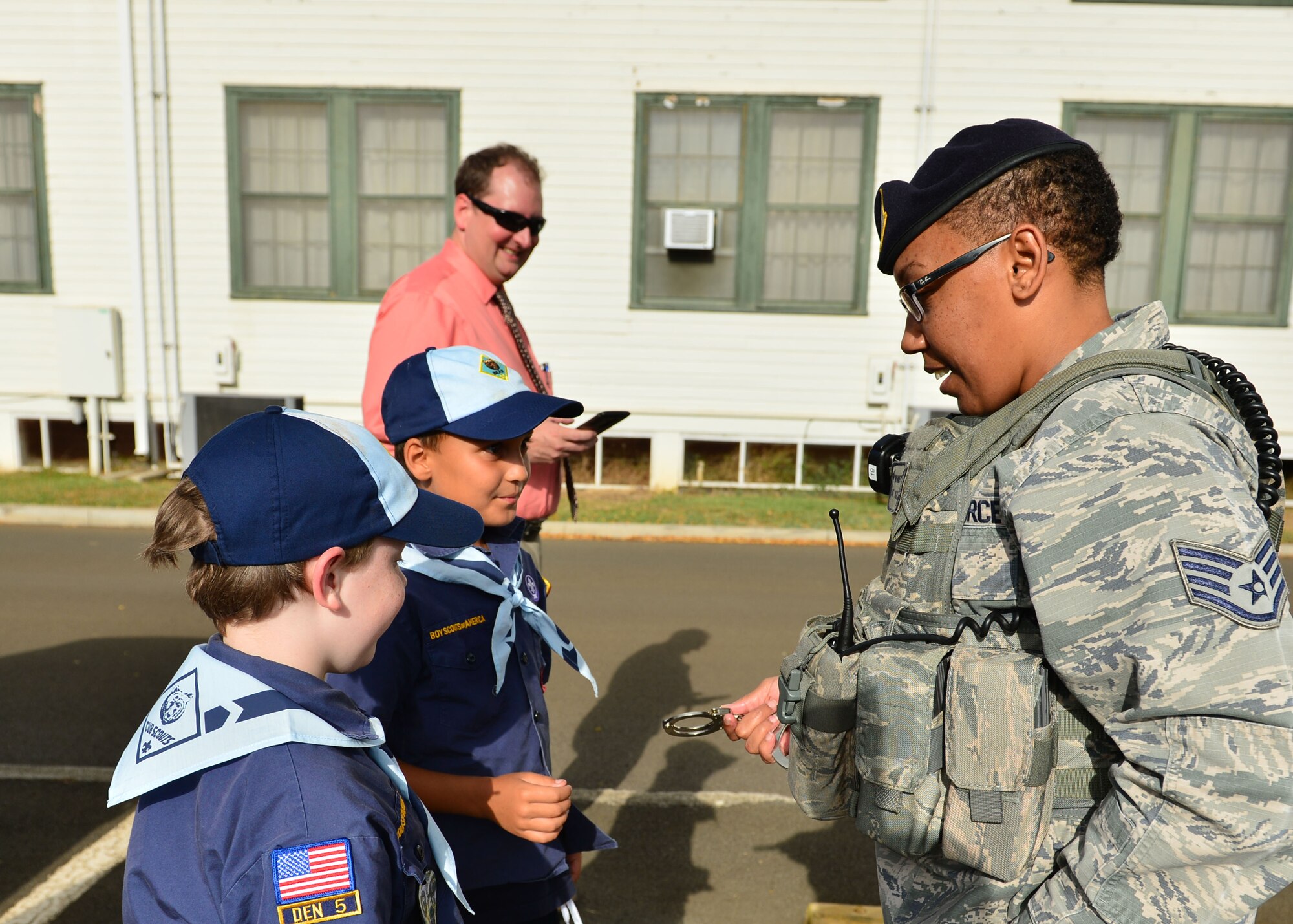 Staff Sgt. Yvonne Burnett, 647th Security Forces Squadron, demonstrates how to unlock a pair of hand cuffs during a Cub Scout Den’s tour of the 647th SFS, on Joint Base Pearl Harbor-Hickam, April 5, 2016. During the tour, members of the 647th SFS provided weapon, fingerprint and vehicle demonstration to the Cub Scouts in Den Five of Pack 388. (U.S. Air Force photo by Tech. Sgt. Aaron Oelrich/Released)