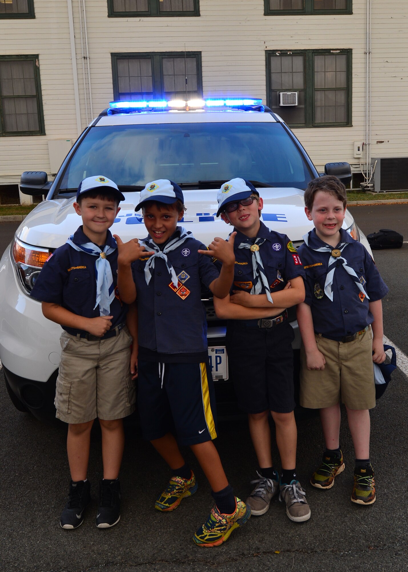 Four Cub Scouts from Pack 388 pose for a photo in front of a 647th Security Forces Squadron patrol vehicle during a tour of the 647th SFS, on Joint Base Pearl Harbor-Hickam, April 5, 2016. During the tour, members of the 647th SFS provided weapon, fingerprint and vehicle demonstration to the Cub Scouts in Den Five of Pack 388. (U.S. Air Force photo by Tech. Sgt. Aaron Oelrich/Released)