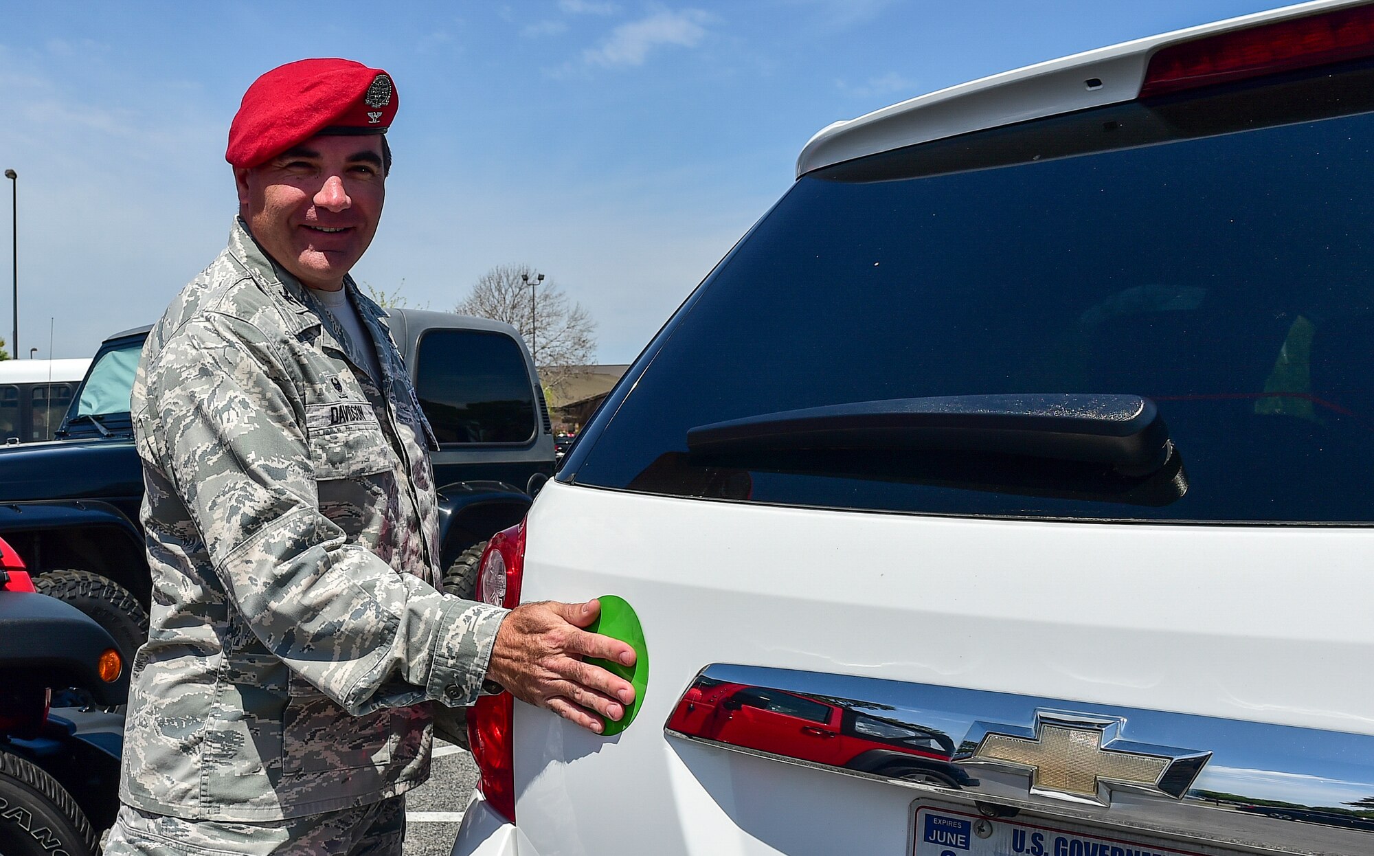 Col. Matthew "Wolfe" Davidson, the commander of the 24th Special Operations Wing, places a green dot magnet on his staff vehicle at Hurlburt Field, Fla., April 6, 2016. Green Dot prepares organizations to implement a strategy of violence prevention that reduces power-based interpersonal violence, including sexual violence, domestic violence, dating violence, stalking, child abuse, elder abuse and bullying. (U.S. Air Force photo by Senior Airman Jeff Parkinson)