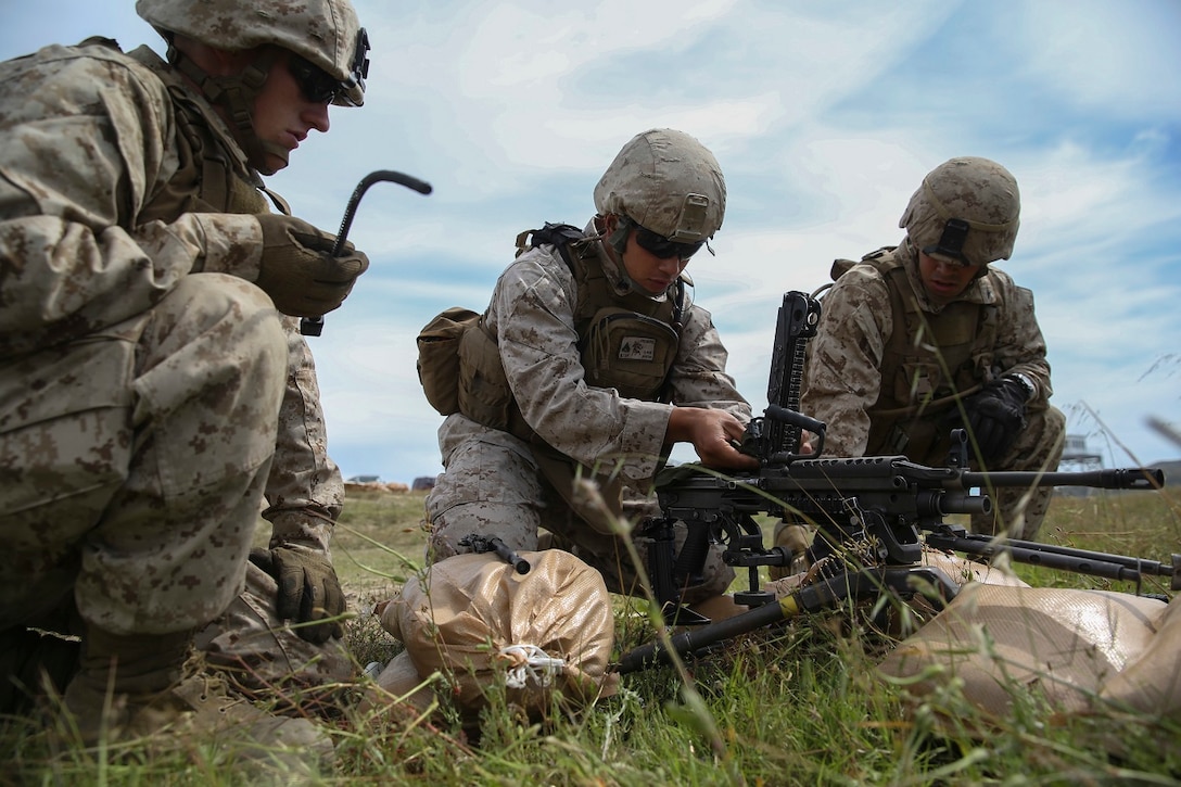 Corporal Jalen Freiberg [center], a machine gunner with Company K, 3rd Battalion, 1st Marine Regiment, 1st Marine Division, cleans an M249 Squad Automatic Weapon prior to conducting live-fire machine gun target engagement aboard Marine Corps Base Camp Pendleton, Calif., April 11, 2016. The M249 is counted on to provide the bulk of each Marine fire team’s firepower while remaining maneuverable. (U.S. Marine Corps photo by Lance Cpl. Timothy Valero/ Released)