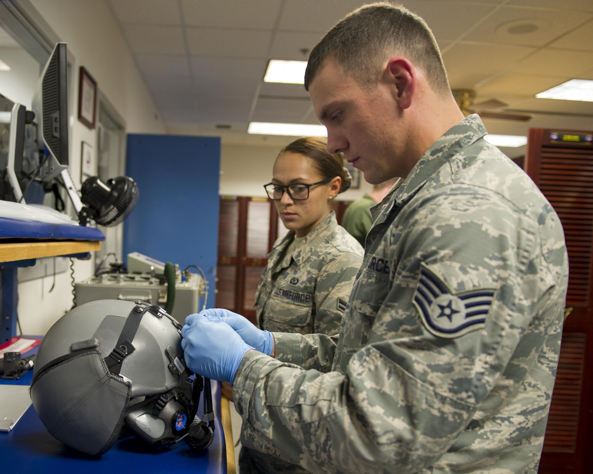 Staff Sgt. Kody Crider and Airman 1st Class Cortney Oehlbeck, 325th Operations Support Squadron/43rd Fighter Squadron Aircrew Flight Equipment technicians, repair a pilot’s helmet April 7, at the 43rd FS. The AFE shop is much like a detachment, comprised of a rotation of 325th OSS Airmen who spend a year at the shop inspecting and maintaining all of the 43rd FS F-22 Raptor pilots’ life support equipment. (U.S. Air Force photo by Senior Airman Alex Fox Echols III/Released)