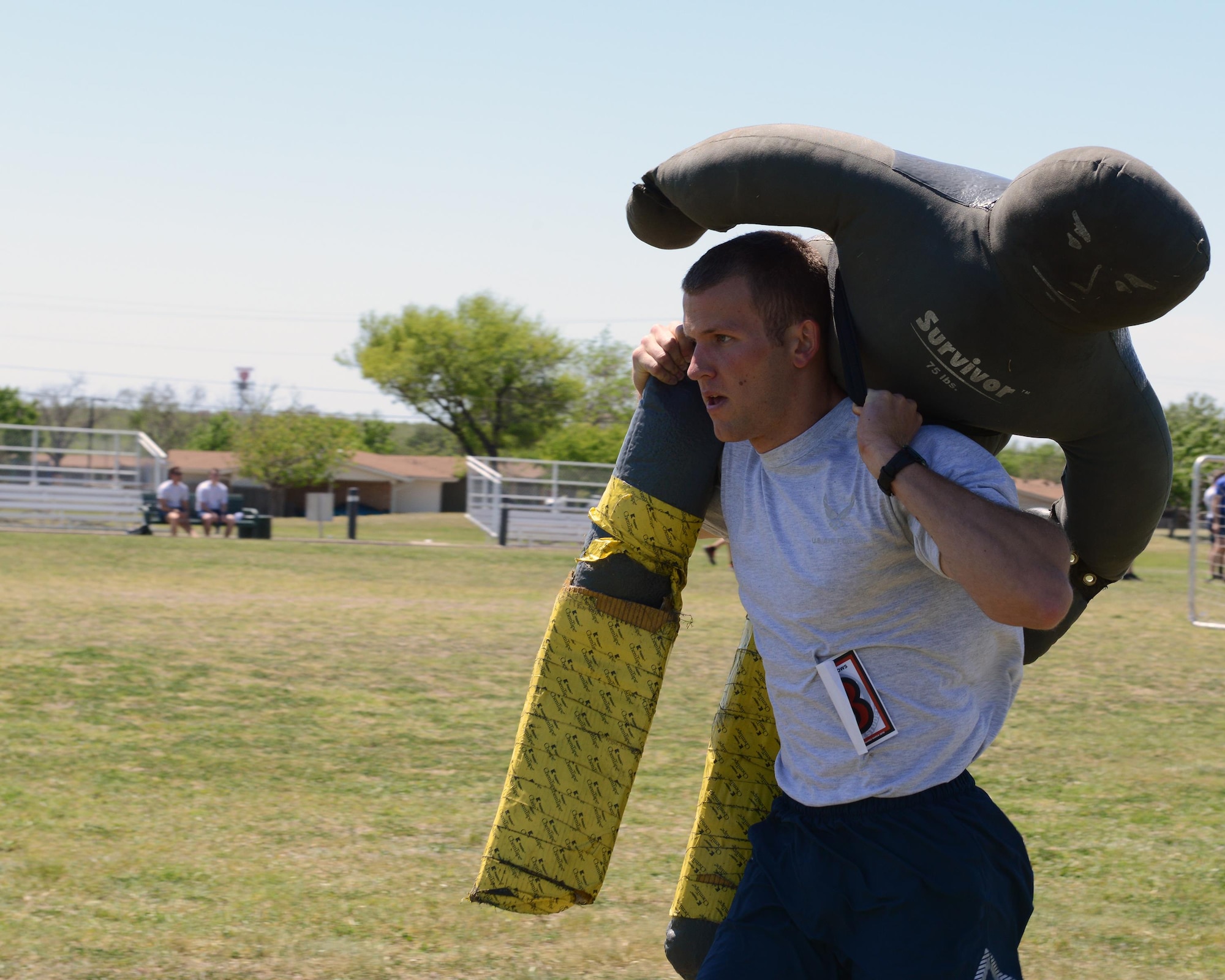 2nd Lt. Christopher Brown, 47th Student Squadron awaiting pilot training, carries a dummy across the football field at Laughlin Air Force Base, Texas, April 5, 2016. The dummy carry involved running a 100 yard sprint with a 75-pound dummy. (U.S. Air Force photo by Senior Airman Jimmie D. Pike) 