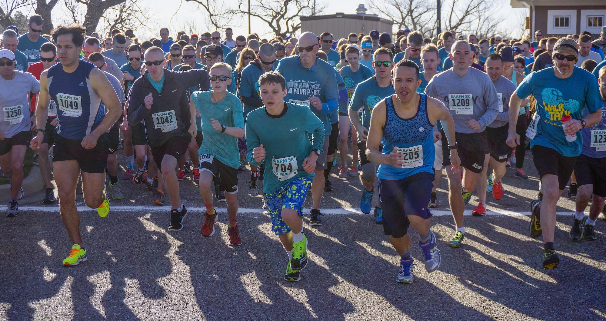 Participants take off from the starting line of the Sexual Assault Awareness 5-kilometer run April 9, 2016, in Lion’s Park, Cheyenne, Wyo. More than 500 participants – including Airmen, Soldiers, Guardsmen and community members – ran, walked and ruck-marched the course. (U.S. Air Force photo by Senior Airman Brandon Valle)