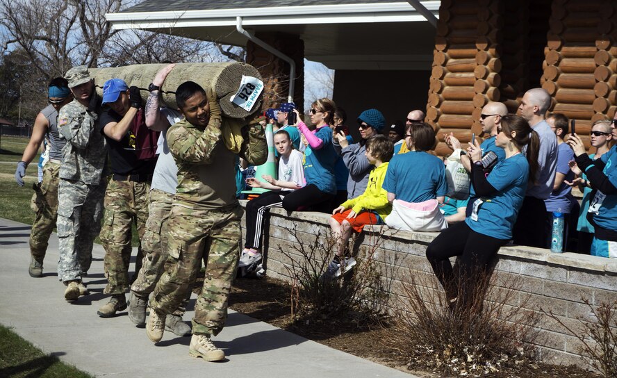 Mighty Ninety Airmen from the 90th Force Support Squadron, 90th Contracting Squadron and the 20th Air Force carry a large log towards the finish line of the Sexual Assault Awareness 5-kilometer race April 9, 2016. Though they finished last, the Airmen carried the log the entire course and did not quit. (U.S. Air Force photo by Senior Airman Brandon Valle)