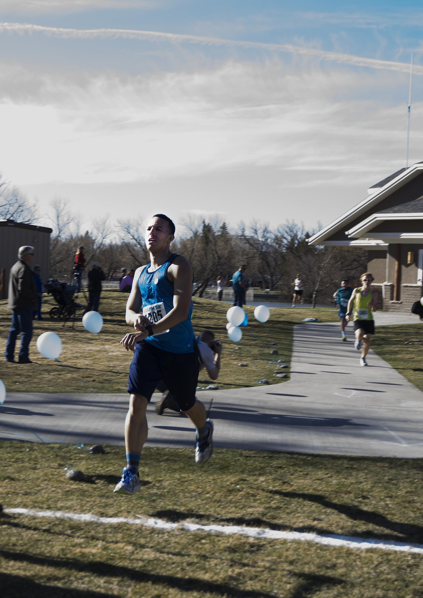 Senior Airman Eric Irizarry, 90th Medical Support Squadron, crosses the finish line of the Sexual Assault Awareness 5-kilometer race April 9, 2016, in Lion’s Park, Cheyenne, Wyo. Irizarry finished second for males, with Senior Airman Aaron Hurtado, 790th Missile Security Forces Squadron, finishing in first place. (U.S. Air Force photo by Senior Airman Brandon Valle
