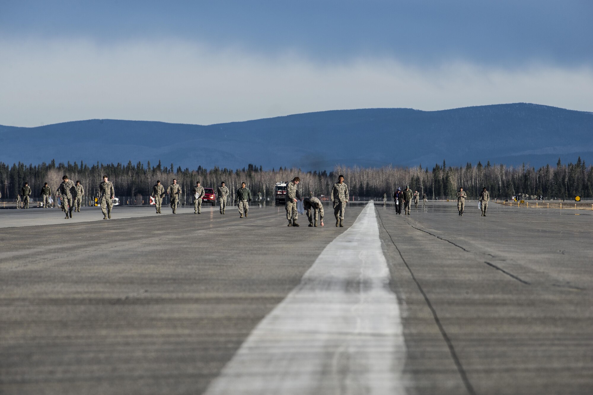 Airmen from Eielson Air Force Base, Alaska, conduct a wing-wide foreign-object debris (FOD) walk, April 11, 2016, to remove materials from the runway that could damage an aircraft during a takeoff or landing. The break-up of snow and preparation for RED FLAG-Alaska 16-1 inspired the FOD walk. (U.S. Air Force photo by Staff Sgt. Joshua Turner/Released)