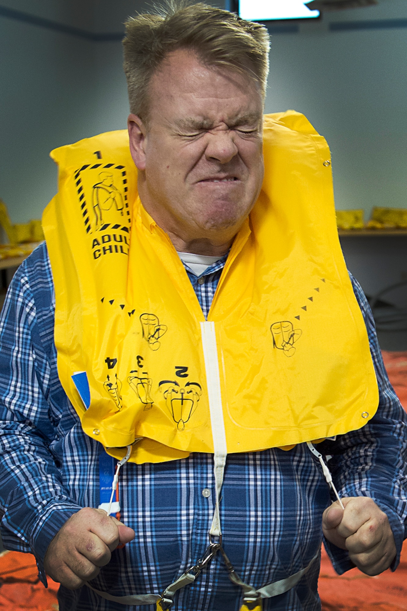 Leilan McNally, 434th Mission Support Group honorary commander, inflates a life vest during a demonstration of aircrew flight equipment by the 434th Operations Support Squadron at Grissom Air Reserve Base, Ind., April 8, 2016. Guests of the 434th Operations Group saw how AFE can be used to save the lives of Airmen in an emergency situation. (U.S. Air Force photo/Senior Airman Dakota Bergl)