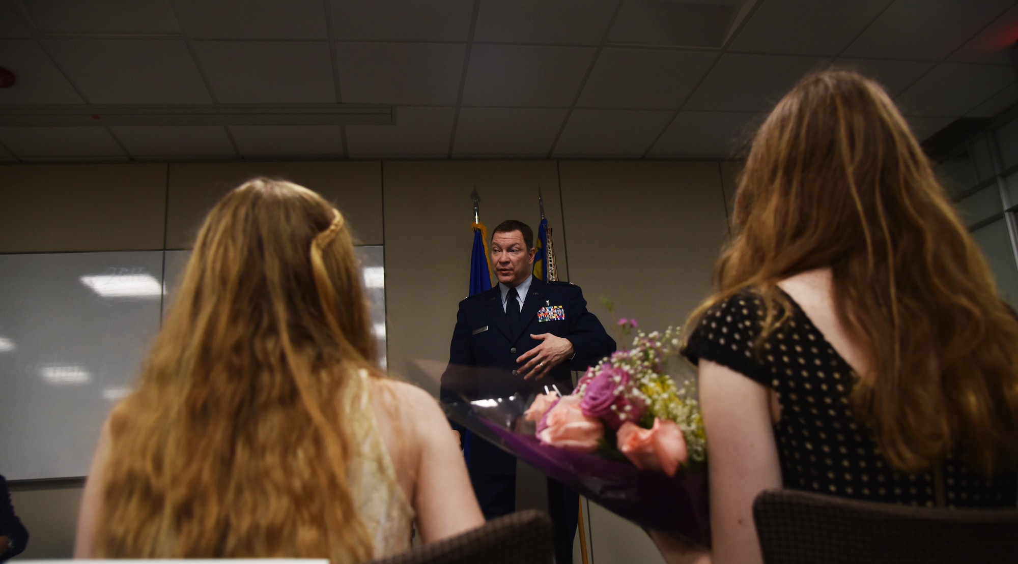During a promotion ceremony and assumption of command, Col. Gary Hopkins, 927th Aeromedical Staging Squadron commander, gave credit to his family for their support and dedication, April 2, 2016. Following the ceremony Hopkins presented his wife and daughters with flowers and hug. (U.S. Air Force photo by Staff Sgt. Adam C. Borgman)