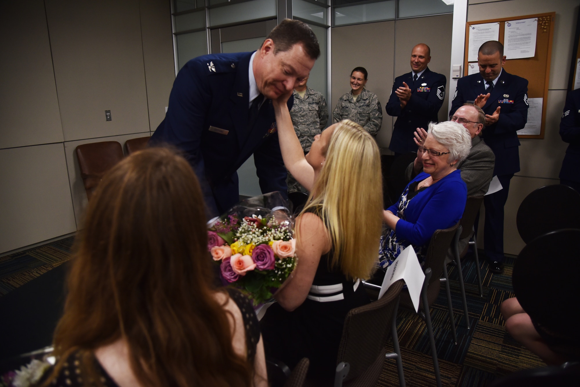During a promotion ceremony and assumption of command, Col. Gary Hopkins, 927th Aeromedical Staging Squadron commander, gave credit to his family for their support and dedication, April 2, 2016. Following the ceremony Hopkins presented his wife and daughters with flowers and hug. (U.S. Air Force photo by Staff Sgt. Adam C. Borgman)
