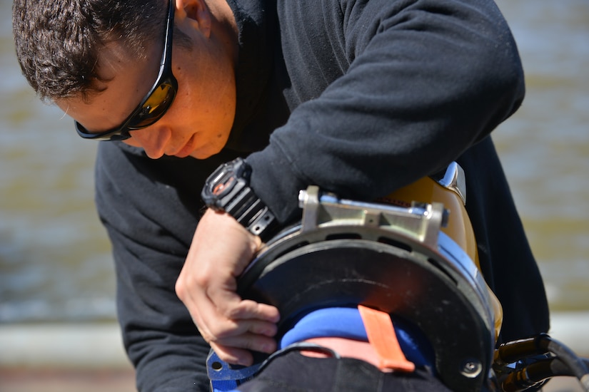 U.S. Army Spc. Michael Singley, a second class diver assigned to the 569th Engineer Dive Detachment, secures a surface supply dive helmet onto another diver at Fort Eustis, Va., March 22, 2016. The surface supply helmet allows for divers to submerge with continuous oxygen and communication supplied by surface lines rather than an underwater tank. (U.S. Air Force photo by Staff Sgt. Natasha Stannard)