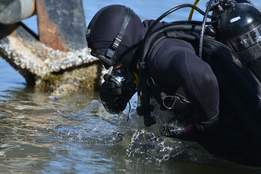U.S. Army Sgt. Gordon Yeaple, a salvage diver assigned to the 569th Engineer Dive Detachment, jumps into the James River at Fort Eustis, Va., March 18, 2016. Army divers support joint and coalition marine missions by conducting reconnaissance, security and engineering surveys as well as underwater construction and demolition. (U.S. Air Force photo by Staff Sgt. Natasha Stannard)